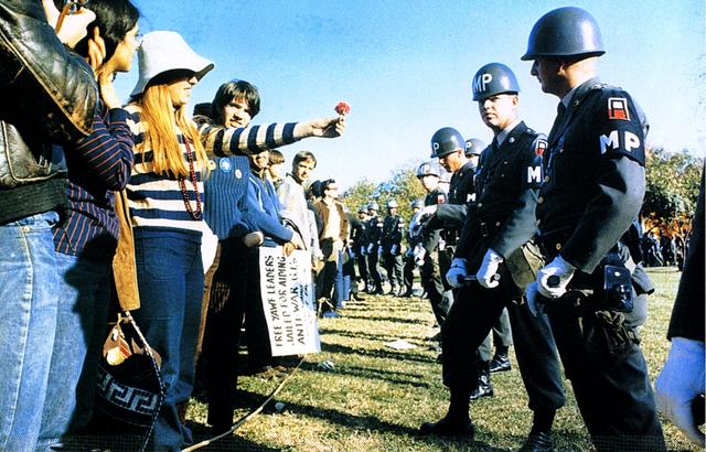 fotografia d'una dona oferint una flor a un membre de les forces policials durant una manifestació contra la guerra al 1967